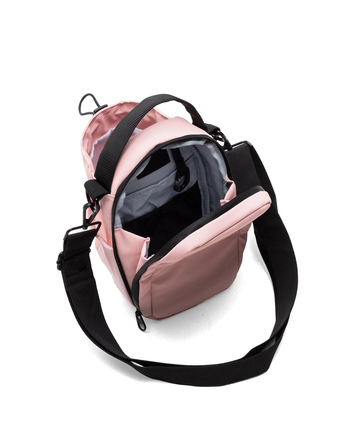 Pink crossbody bag with black strap on a white background