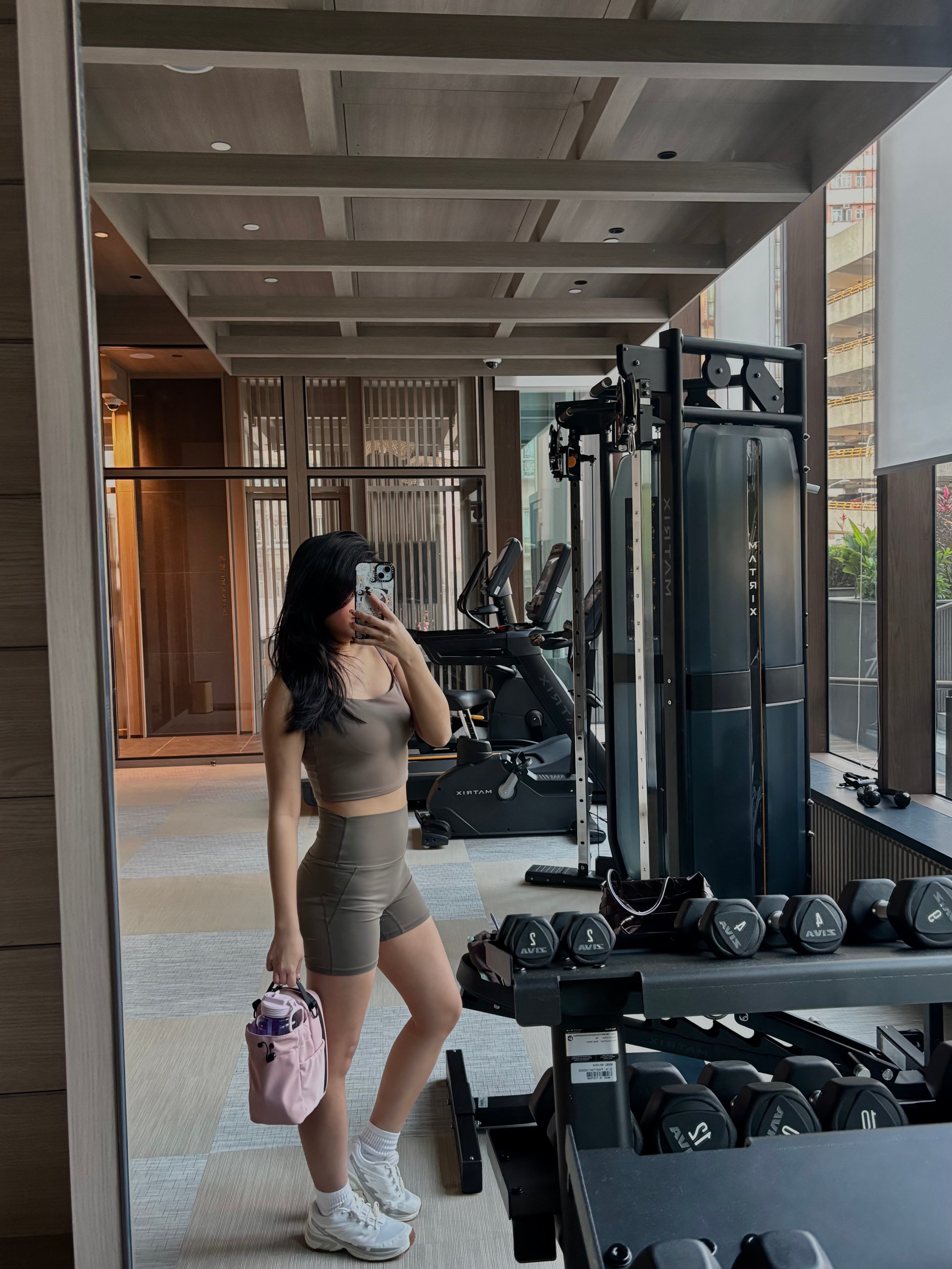 Woman taking a mirror selfie in a gym setting